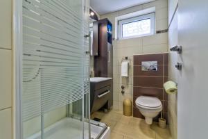 ein Bad mit einer Dusche, einem WC und einem Waschbecken in der Unterkunft Apartments Bobinac in Senj