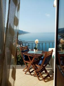 einen Tisch und Stühle auf einem Balkon mit Meerblick in der Unterkunft Un Oblò sul Mare in San Lucido