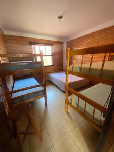 a room with two bunk beds and a chair at Pousada Residencial Paineiras in Guaratuba