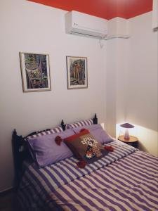 a bedroom with a bed with a blue and white striped blanket at MimaDart Pop-up Gallery Apartment in Piraeus