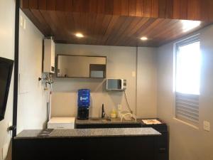 uma pequena cozinha com um lavatório e um micro-ondas em Condomínio Max Savassi Superior apto 1302 em Belo Horizonte