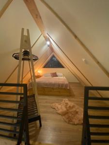 Dormitorio en el ático con cama y escalera en Stodoła na polanie, en Poronin