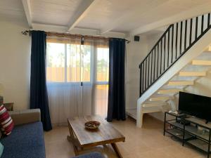 sala de estar con escalera, sofá y mesa en Casa Ilaria Fuerteventura -Wifi free, en Corralejo
