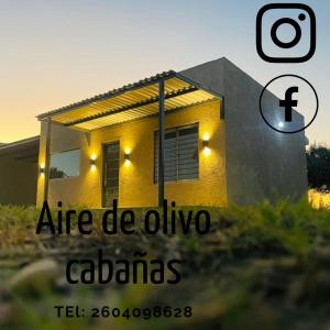 una casa amarilla con las palabras comidas de oliva calabas en Aire de Olivo Cabañas en San Rafael