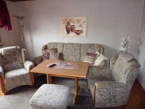 ein Wohnzimmer mit einem Sofa, einem Tisch und Stühlen in der Unterkunft Ferienwohnung Kraemer in Erbach in Erbach