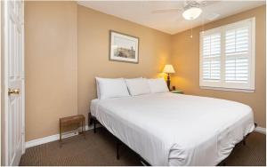 Un dormitorio con una cama blanca grande y una ventana en Royal Palms Unit 906, en Gulf Shores