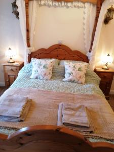 um quarto com uma cama de madeira e 2 mesas de cabeceira em Poplar Cottage em Woodhall Spa