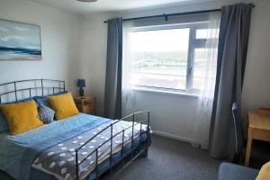 a bedroom with a bed in front of a window at The Haven, Fishguard, ideal for Beach, coastal path and town! in Fishguard