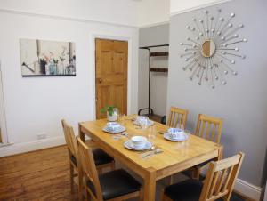 a dining room with a wooden table and chairs at Lovely 3 beds house 6 guests King beds in Sheffield