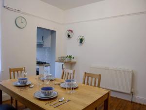 a wooden table with plates and wine glasses on it at Lovely 3 beds house 6 guests King beds in Sheffield