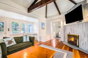 a living room with a couch and a fireplace at Barefoot Cottage Pool House in Grand Beach