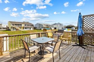 una terrazza con tavolo, sedie e ombrellone di Carolina Coasting ad Atlantic Beach