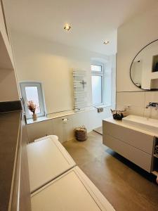 La salle de bains est pourvue d'un lavabo et d'un miroir. dans l'établissement Ferienwohnung Obernkirchen, à Obernkirchen