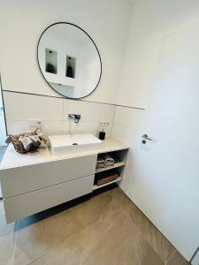 a bathroom with a white sink and a mirror at Ferienwohnung Obernkirchen in Obernkirchen