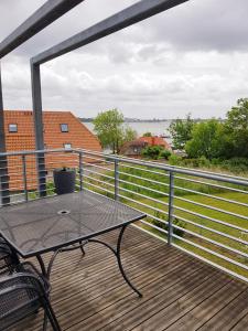 un patio con mesa y sillas en una terraza en Ferienwohnung MeerBlick OG, en Altefähr