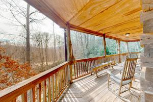 a porch with two chairs and a bench on it at Glass Mountain Treehouse in Fairview