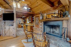 a living room with a fireplace and a tv at Glass Mountain Treehouse in Fairview