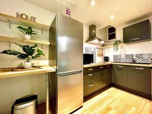 una cucina con frigorifero in acciaio inossidabile e pavimenti in legno di *Le Namasté*Fibre Wifi*Hyper Centre* a Salon-de-Provence