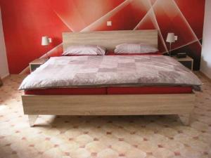 a bedroom with a large bed with a red wall at Klaschter Gastewohnung in Groß-Umstadt