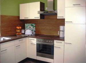 a kitchen with white cabinets and a stove top oven at Klaschter Gastewohnung in Groß-Umstadt