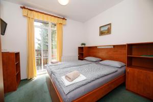 Svycarska Bouda في سبيندلروف ملين: غرفة نوم بسرير ونافذة كبيرة