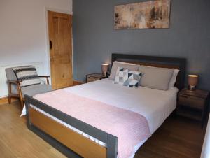 a bedroom with a large bed and a chair at Lovely 3 beds house 6 guests King beds in Sheffield