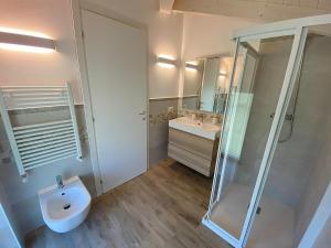 een badkamer met een toilet, een douche en een wastafel bij Maison Mimi apartments in Ossuccio