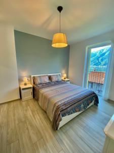 1 dormitorio con cama y ventana grande en Maison Mimi apartments, en Ossuccio
