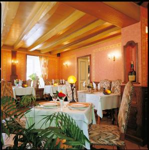CérillyにあるHotel Chez Chaumatの白いテーブルと椅子のあるレストラン、