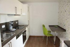 eine kleine Küche mit einem Tisch und Stühlen in der Unterkunft Ferienwohnung am Nibelungensteig in Lautertal