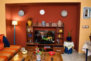 Dar Marrakech Apartment Sousse في حمام سوسة: غرفة معيشة مع أريكة وتلفزيون