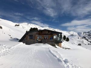 a log cabin in the snow on a mountain at Pfefferkornhütte in Warth am Arlberg