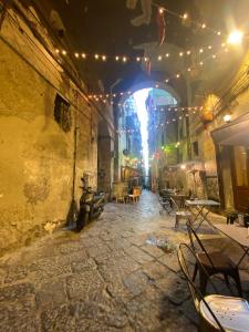 an alley with tables and chairs in a building with lights at Casa Viscardi in Naples