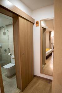 uma casa de banho com um WC, um chuveiro e um espelho. em Sahariano hotel City Center em Laayoune