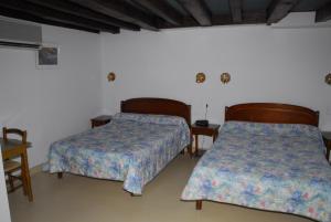 a bedroom with two beds and a table and chairs at Hotel Chez Chaumat in Cérilly