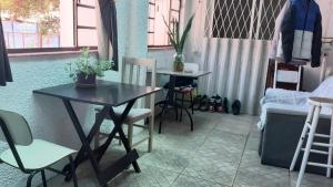 a dining room with a table and chairs and a couch at Arco Iris Guest House in Porto Alegre