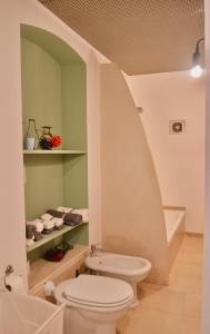 La salle de bains est pourvue de toilettes blanches et d'un lavabo. dans l'établissement Villetta Marianna, à Bari Palese