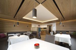 a restaurant with white tables and chairs and a person at Pension Gallus in Lech am Arlberg