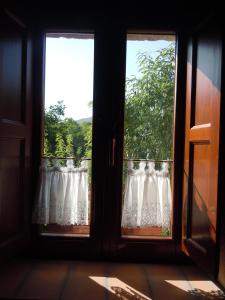 twee ramen met kanten gordijnen in een kamer bij La Casa Sù Le Dimore Del Borgo in Santo Stefano di Sessanio