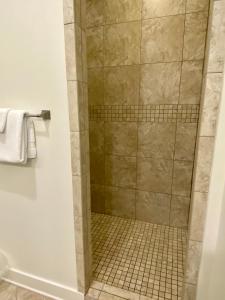 a shower in a bathroom with a tiled floor at The Summer Palace in Inlet Beach