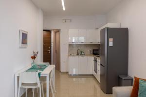 uma pequena cozinha com uma mesa e um frigorífico em Danae Luxury Apartment - Rhodes in Ilha de Rhodes