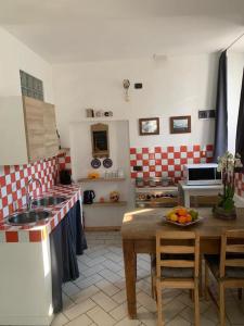 una cocina con fregadero y una mesa con un bol de fruta en In Piazzetta - Cernobbio, en Cernobbio