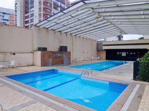 - une grande piscine d'eau bleue dans un bâtiment dans l'établissement Aconchegante Maravilhoso Flat Congonhas 1416, à São Paulo