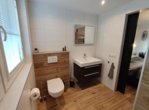 łazienka z toaletą, umywalką i łóżkiem w obiekcie Luxe Kamer aan Zee w mieście Zoutelande