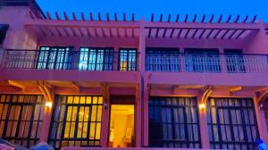 ein rosafarbenes Gebäude mit Fenstern und Licht in der Unterkunft Villa Marrakech in Marrakesch