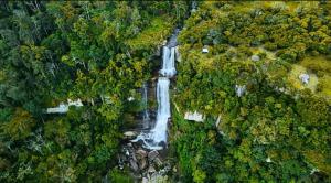 an aerial view of a waterfall in a forest at mirador el paraíso in San José de Suaita