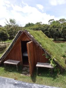 a small hut with two benches in the grass at mirador el paraíso in San José de Suaita
