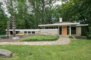 uma pequena casa no meio de um quintal em Mid Century Modern Milwaukee House Spring Vacation em River Hills