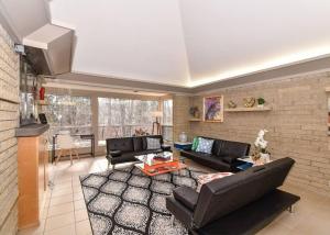 uma sala de estar com dois sofás e uma mesa em Mid Century Modern Milwaukee House Spring Vacation em River Hills