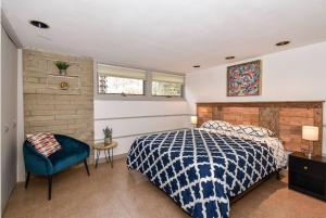 1 dormitorio con 1 cama y 1 silla azul en Mid Century Modern Milwaukee House Spring Vacation, en River Hills